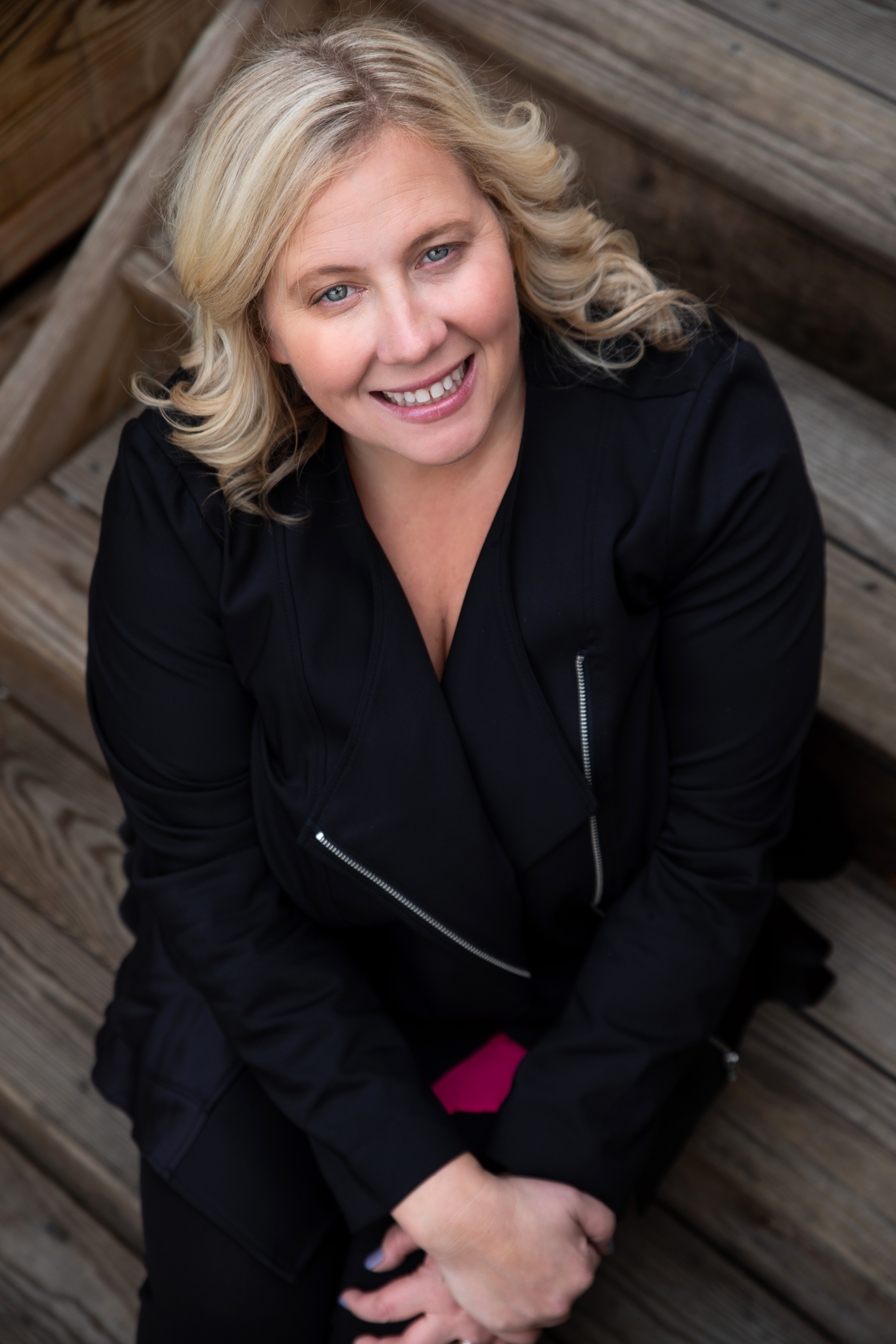 A woman dressed in black smiles up at the camera