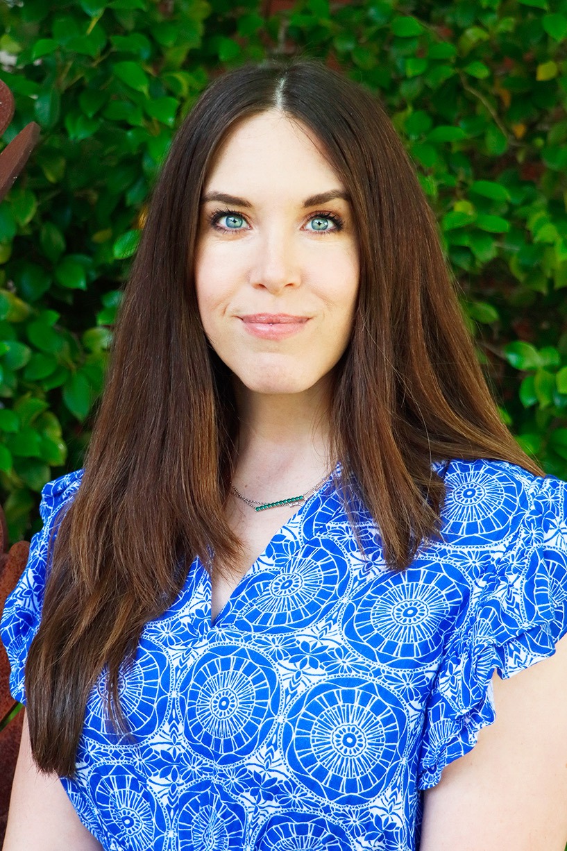 A woman with brown hair and a blue and white shirt smiles at the camera