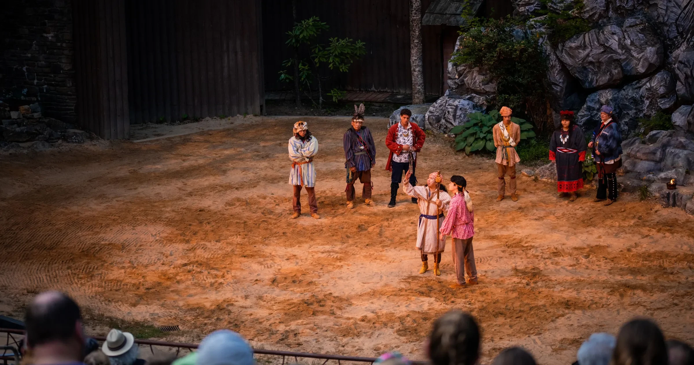 Actors on stage of "Unto These Hills" outdoor drama with patrons in audience.