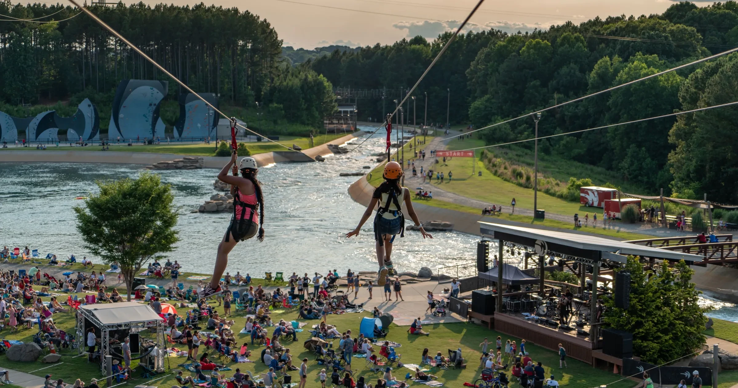 Two women zip-lining over the grounds at the U.S. National Whitewater Center in Charlotte, NC.