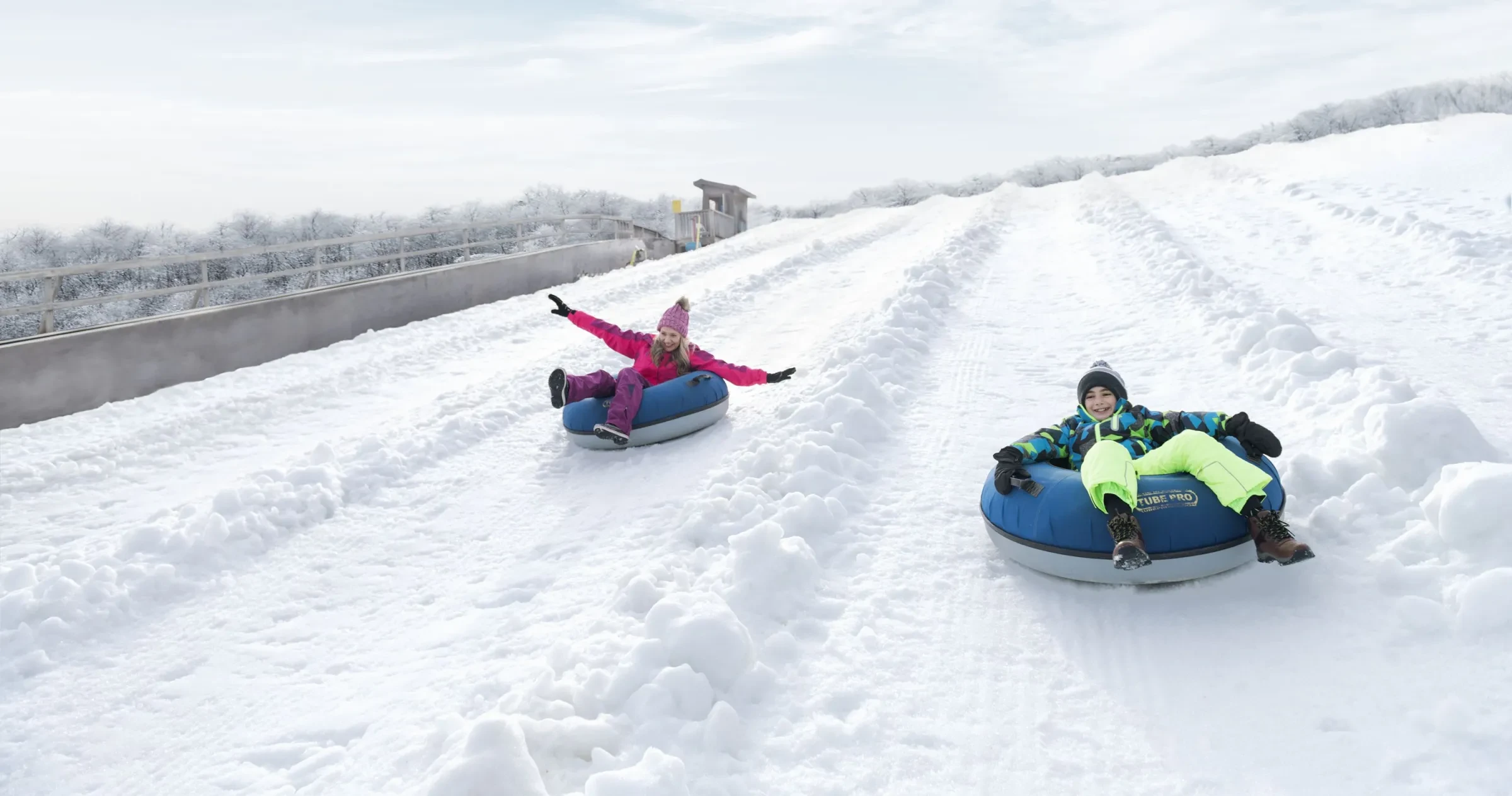 Mother and son snow tubing at Beech Mountain Ski Resort during daytime.