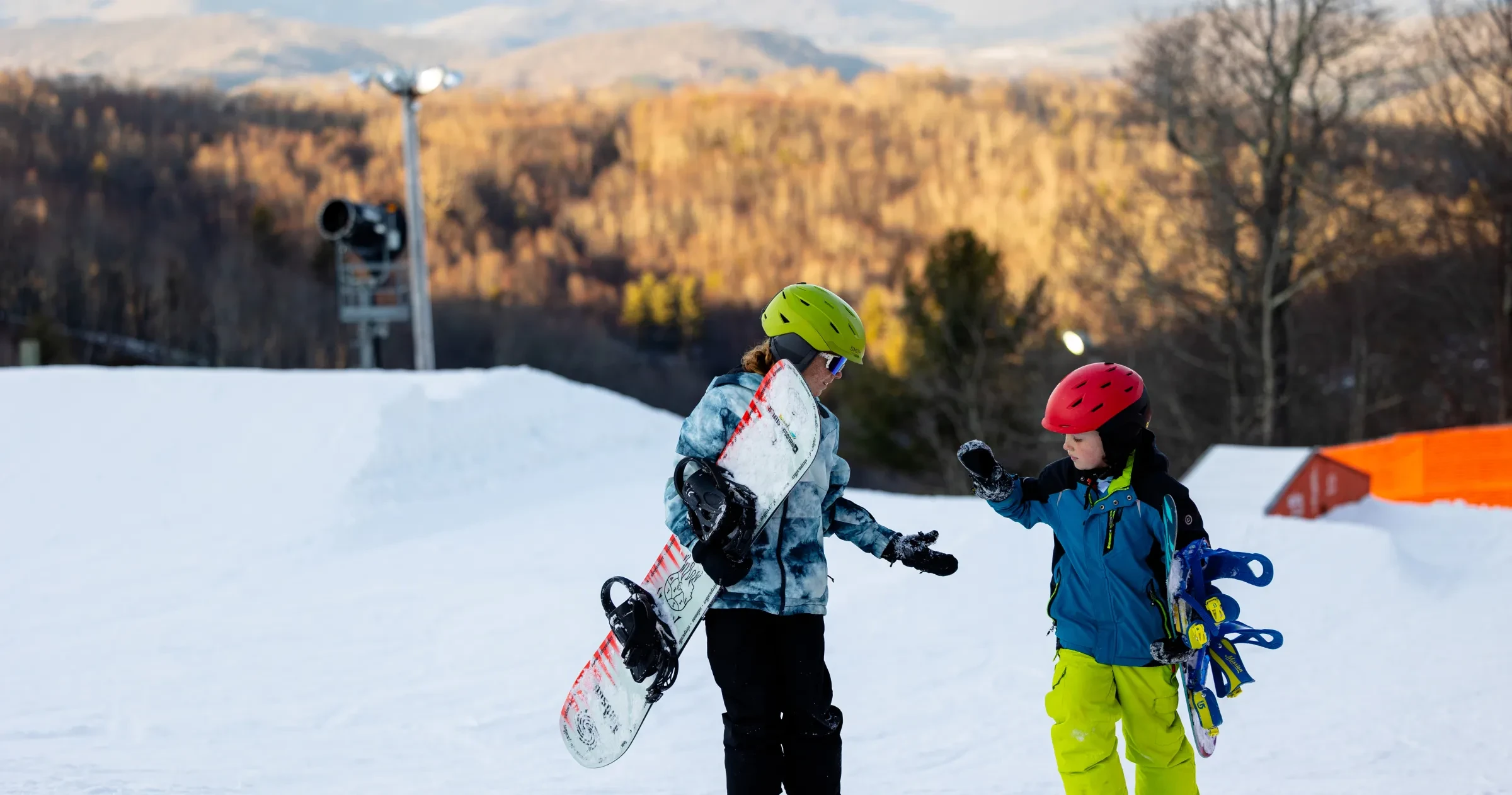 Two young snowboarders celebrate after hitting a jump at App Ski Mountain near Blowing Rock