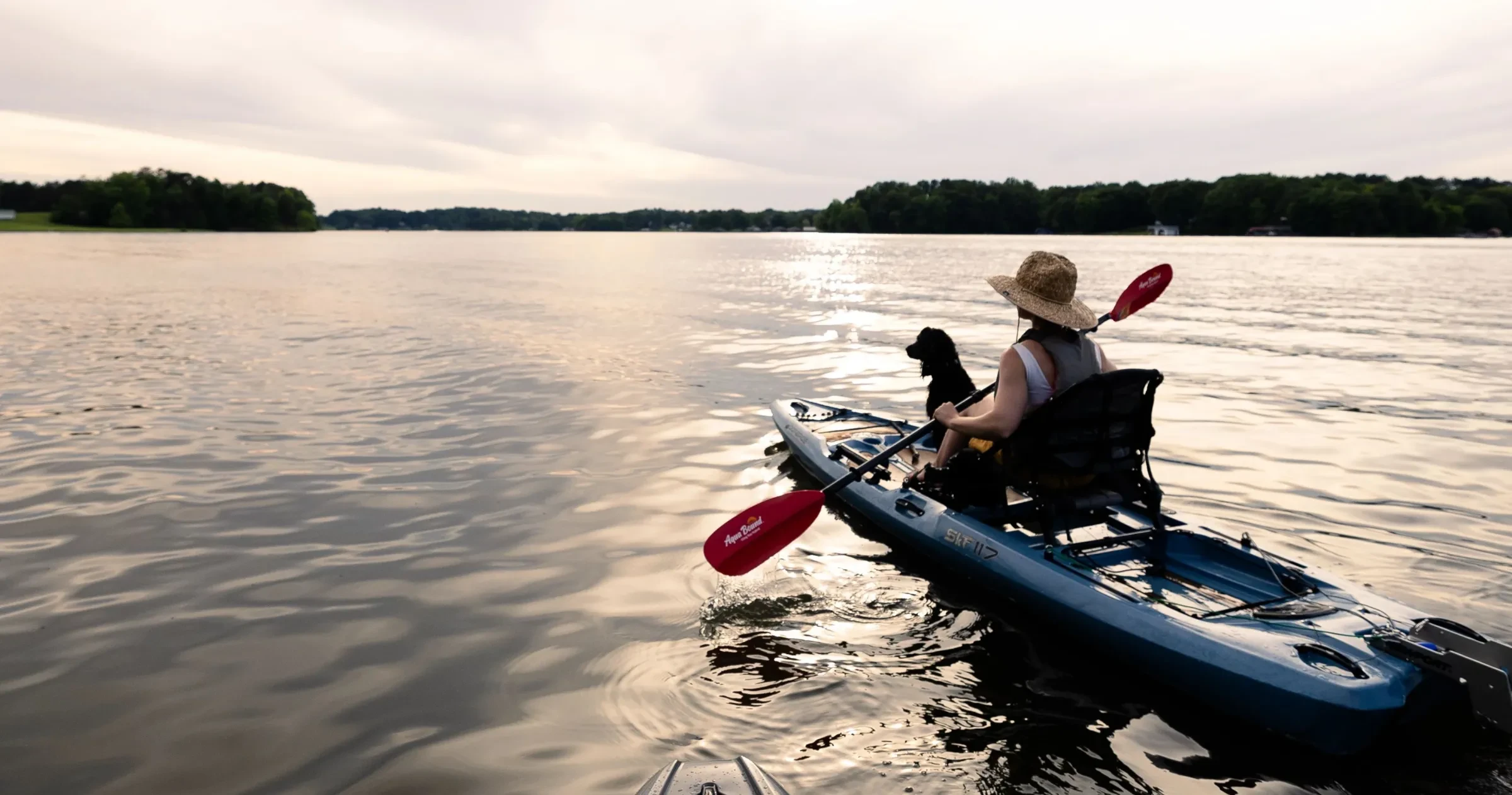 A woman and her dog paddle off into the sunset on a warm summer evening on Hyco Lake. 