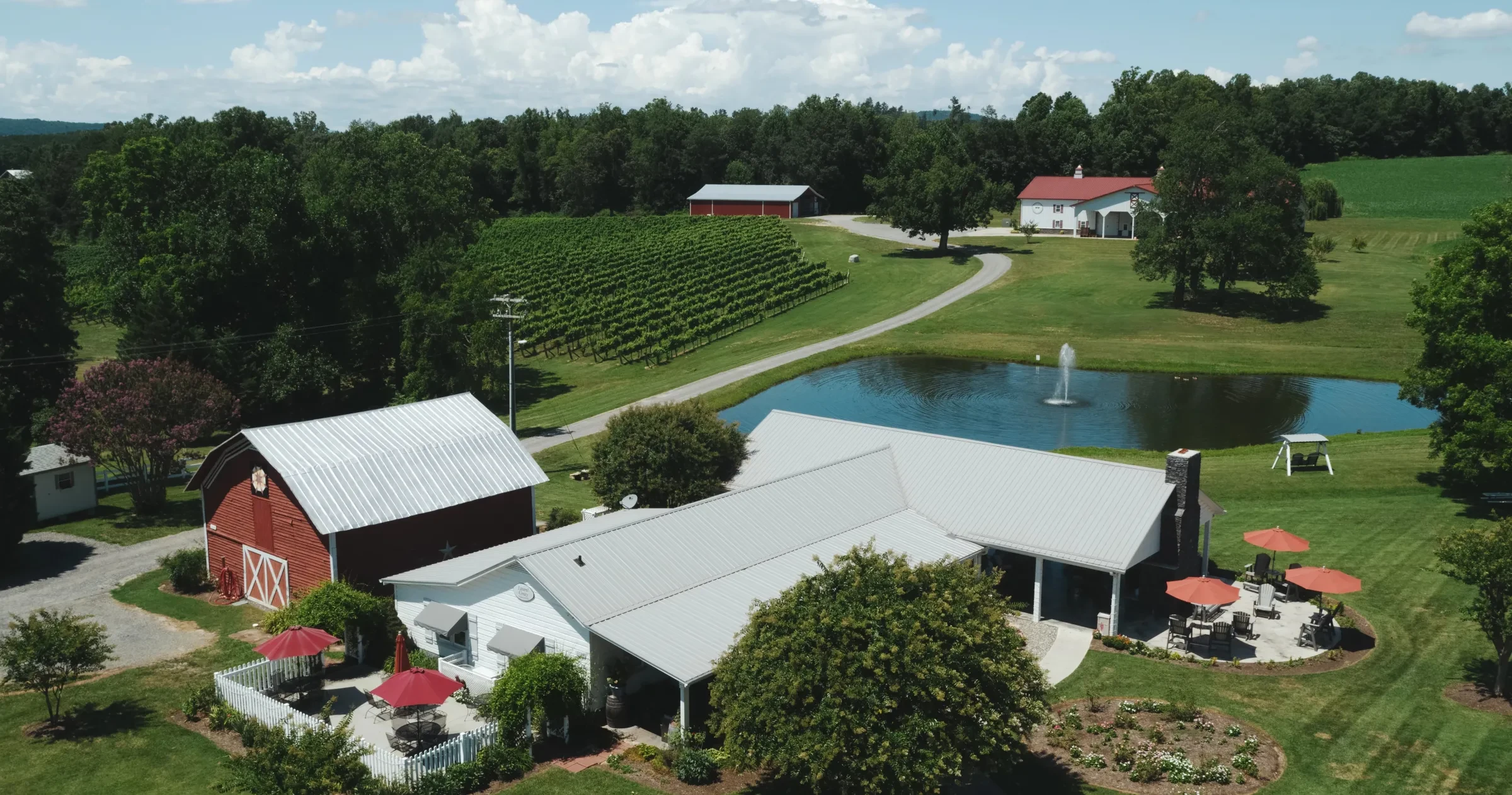Aerial view of Laurel Grey Vineyards in Hamptonville on sunny day with vineyards, buildings, patios and lawn all visible