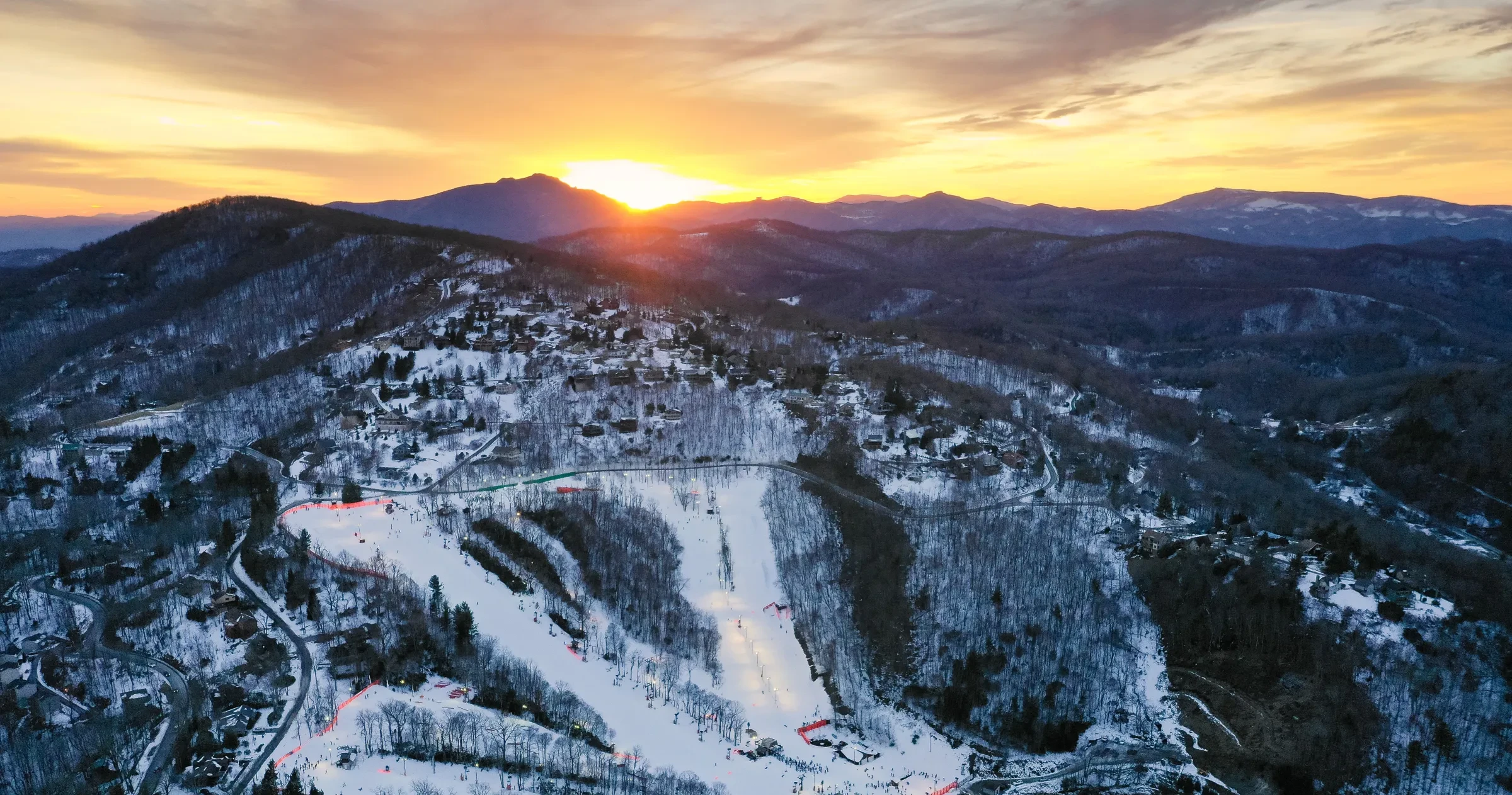 Aerial of Appalachian Ski Mtn. resort with sun setting in background.