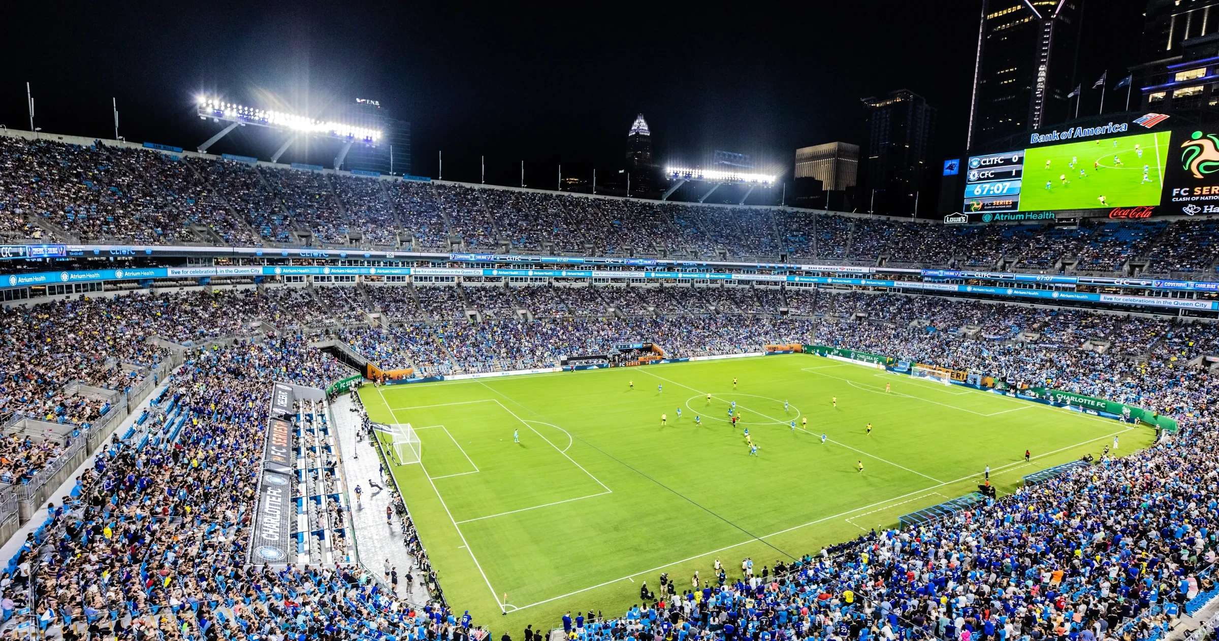 Wide view of soccer stadium at night with players on field