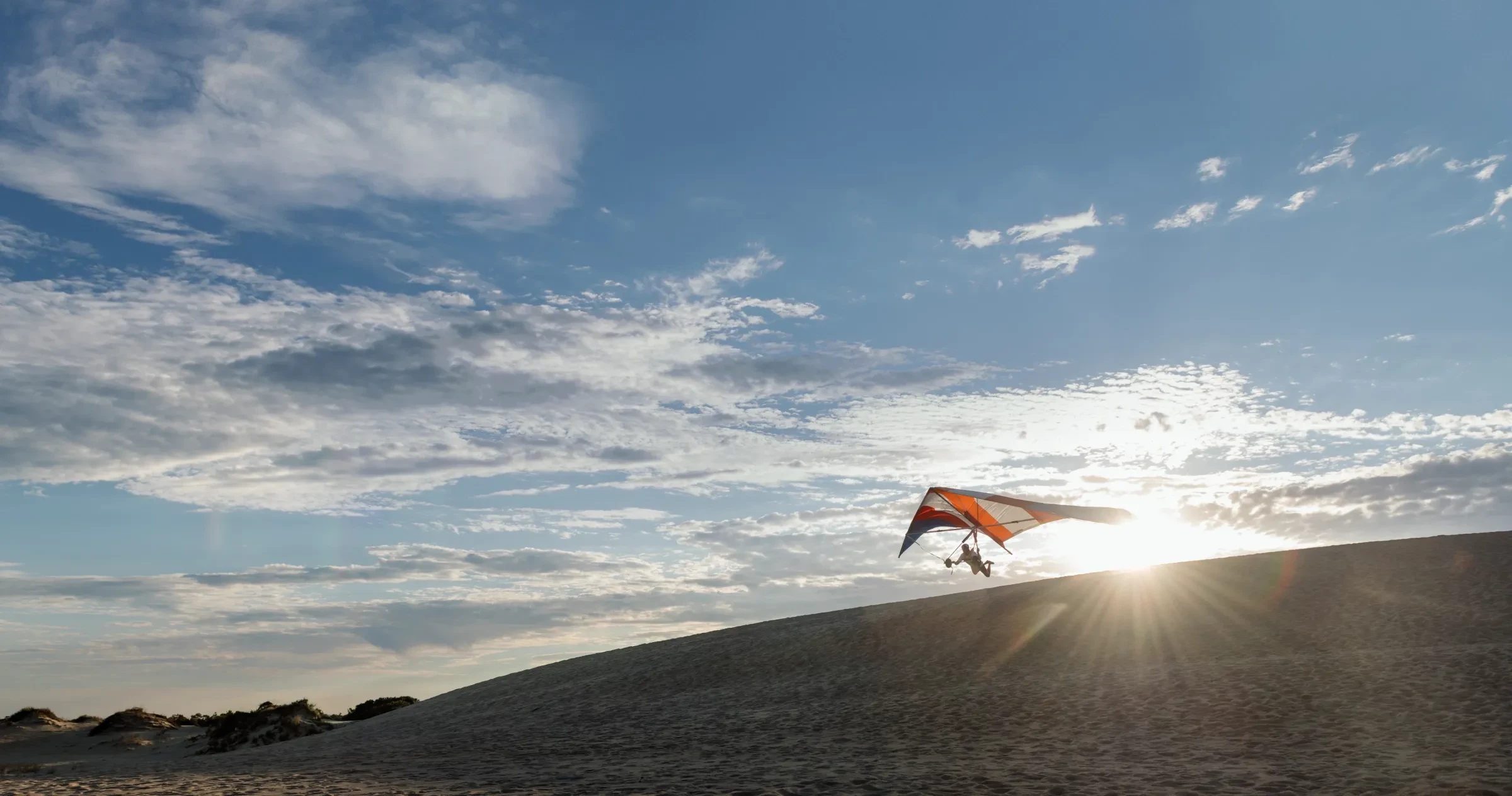 Person hang gliding off sand dune at Jockey's Ridge State Park.