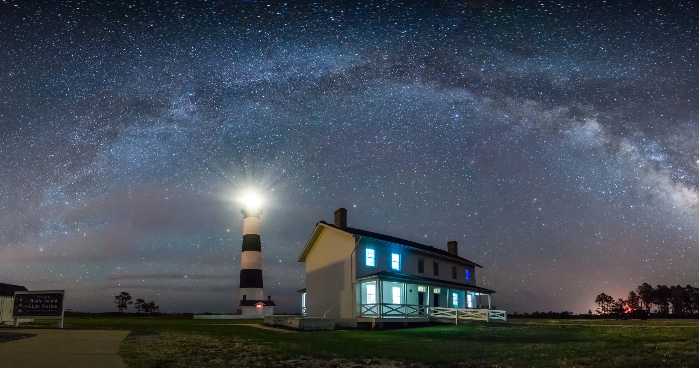 The Bodie Island Lighthouse beacon shines out against a dark sky.
