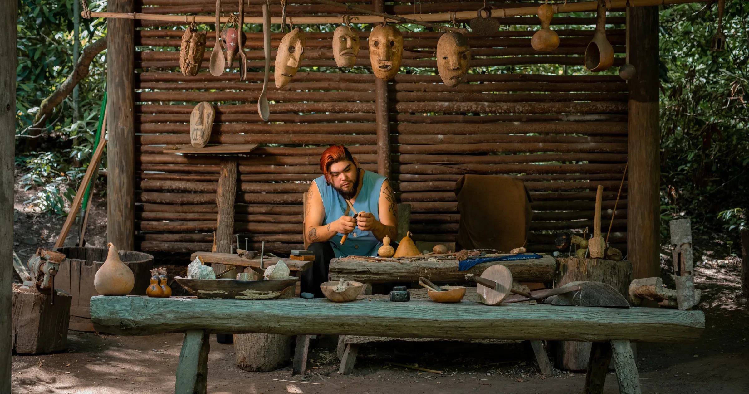 Person working on hand-crafted art in Oconaluftee Indian Village.