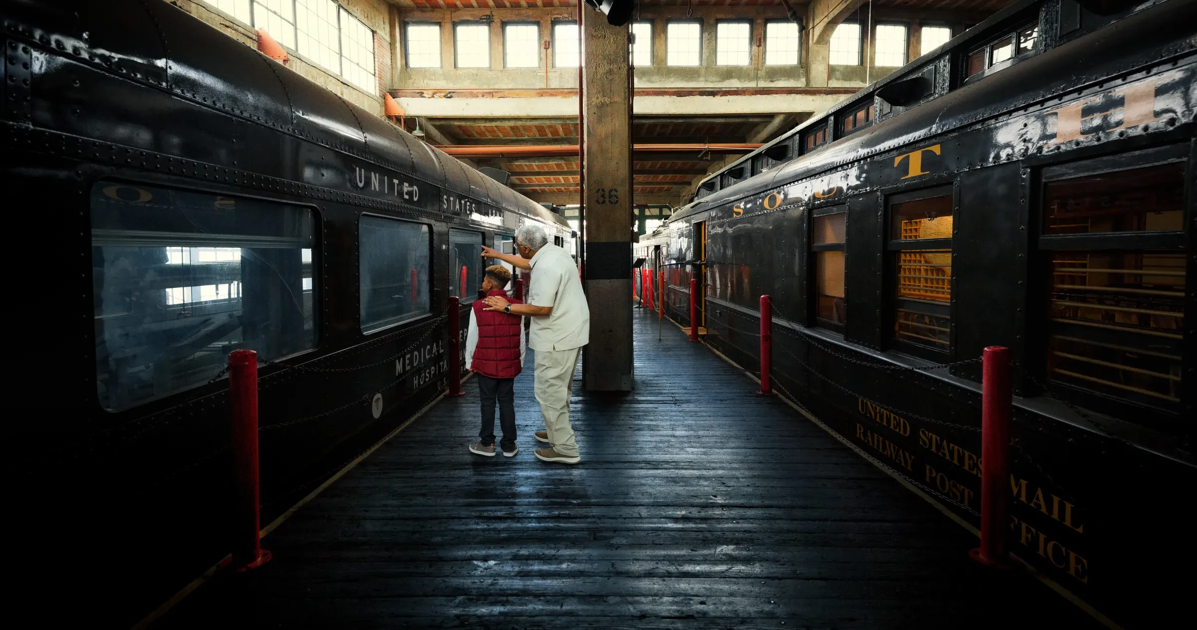 Man and child observing an old train at the N.C. Transportation Museum 
