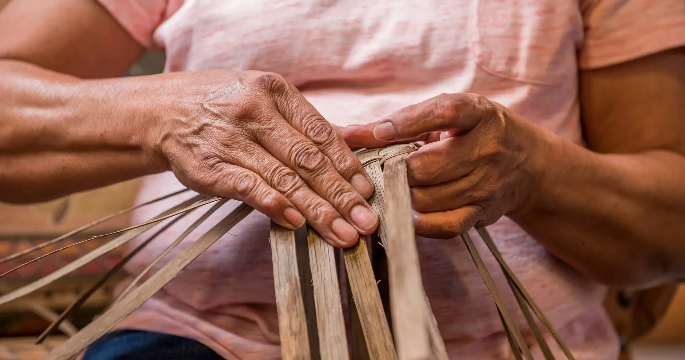 Closeup of hands weaving a basket at Qualla Arts and Crafts Mutual.