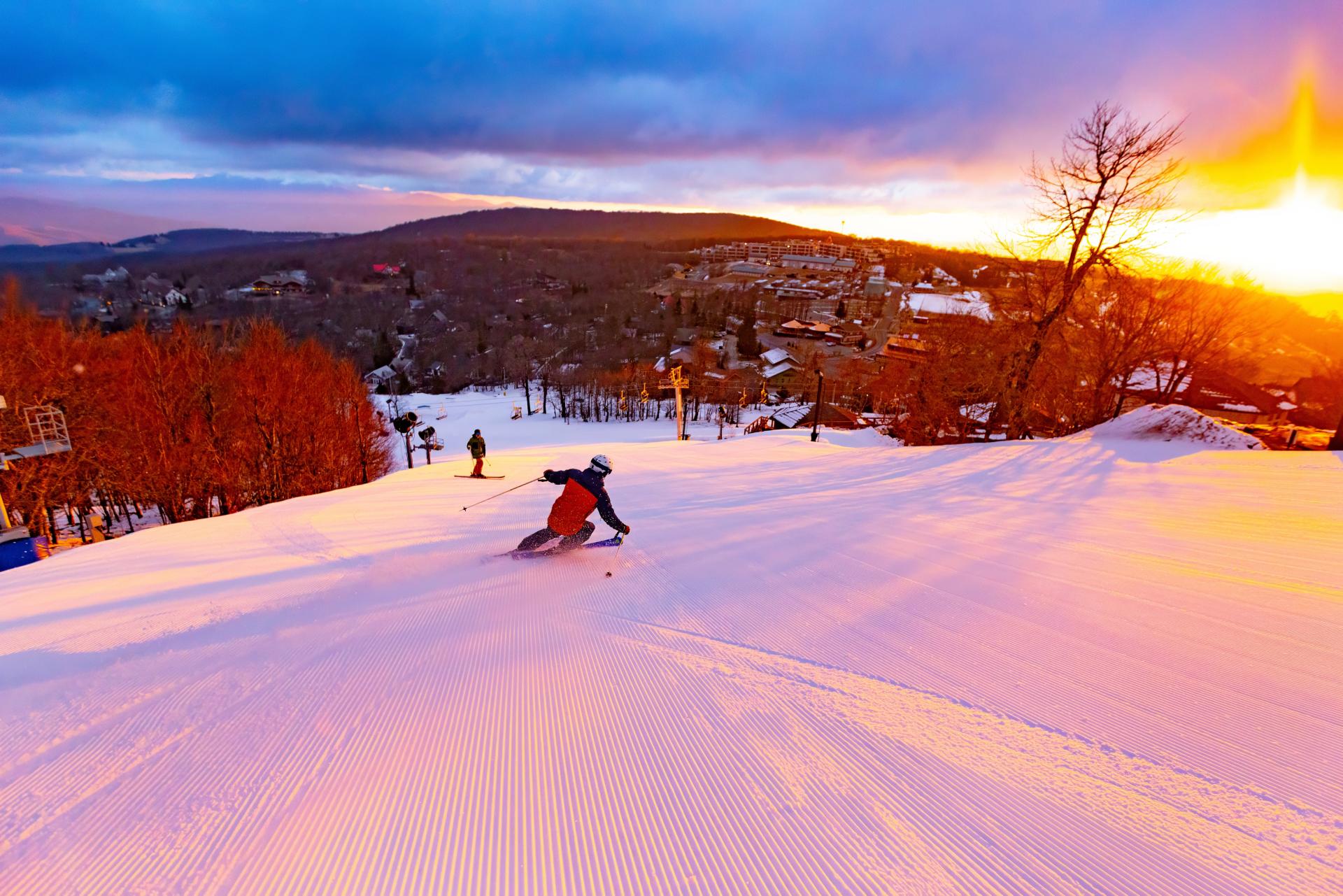 Skiier at sunset speeds down the slopes of Beech Mountain Resort