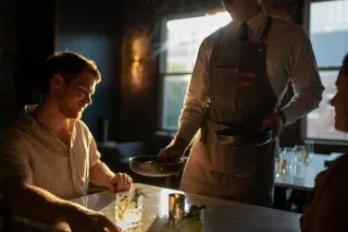 Couple served food at dinner table by waitress