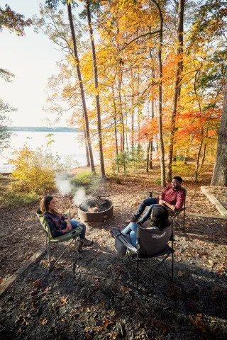 Vertical birds eye view of people gathered around a smoky fire in fall at Badin Lake Campground in the Uwharrie Mountains. 
