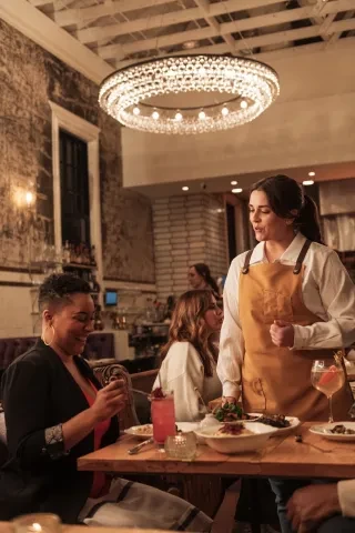 Woman smiling as she tries her dish at Supperland in Charlotte, NC.