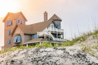 Exterior of the Inn at Rodanthe as seen in the Nicholas Sparks movie, Night in Rodanthe with the sun gleaming from behind.