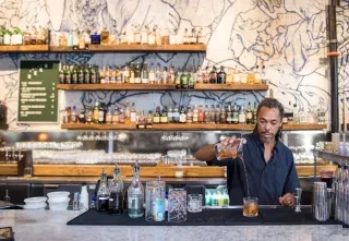 A male bartender pours an elegant cocktail at the stylish interior of Whiskey Kitchen in Raleigh