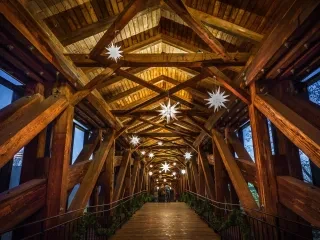 Landscape shot of wooden covered bridge in Old Salem in Winston Salem. Roof beams decorated with Moravian Christmas Decorations and railings decorated with garland. 