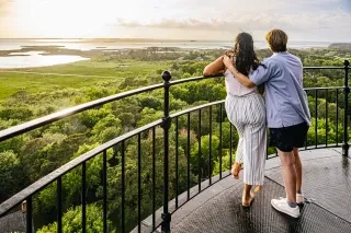Couple admiring the view from the top of Currituck Beach Lighthouse of the surrounding seashore.
