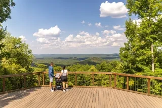 A young family enjoys the view at overlook atop Morrow Mountain in Morrow Mountain State Park, taking in the panoramic views of the surrounding landscape. The overlook provides a spectacular 180 degree panorama view of the surrounding mountains and beauty of the Uwharrie National Forest.