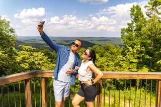 Couple taking selfie at Morrow Mountain State Park with pretty mountainous view in background.