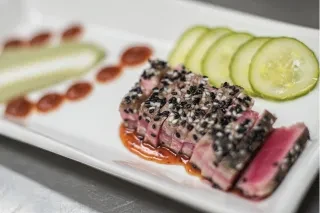 Closeup of sesame tuna on artfully crafted plate.