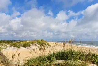 Beautiful Coquina Beach sand and small dunes with beach in background on NC's Outer Banks.