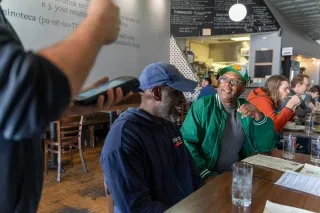 Chef Ricky Moore ordering sitting next to a friend and ordering at Toast in Durham.
