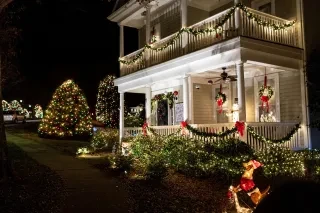 Christmas lights twinkle all over a home porch at night for Christmastown U.S.A in McAdenville