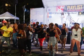 People dancing at Playlist in the Park in Durham Central Park at night.