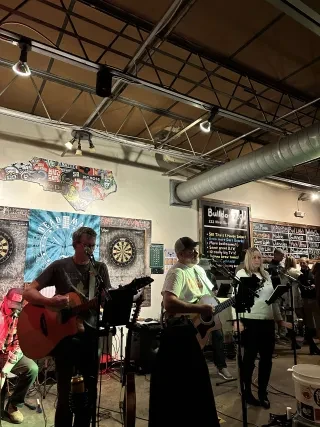 Band playing at dive bar with North Carolina signage in background.