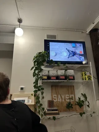 Latte art competition on TV with coffee on TV stand.