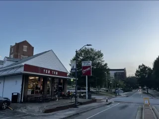 Exterior of ice cream shop on corner of street in Greensboro at dusk.