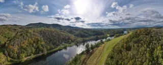 Aerial of New River surrounded by fall foliage and mountains during daytime.