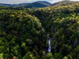 Aerial view of green mountain range with Silver Run waterfall visible cascading down in the bottom right corner.
