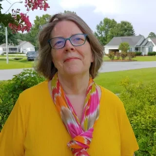 Featured local Cindy Brookshire smiling at camera while wearing yellow shirt.