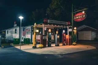 Exterior of old timey Stancil Oil Co. general store and gas station at night.