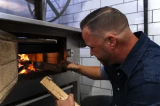 Man stoking an oven fire
