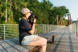 Elizabeth Clark and her dog sitting on Hickory's Riverwalk.