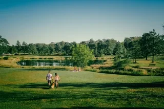 Landscape Drone shot at Howell Woods Environmental Learning Center at Johnston Community College campus in Four Oaks. Park view of the pond and surrounding areas as people share the outdoor space walking their dog, kayaking and Picnicking.