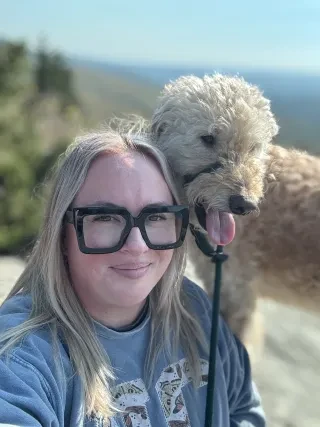 Headshot of Mary Kate Ollis of Village of Sugar Mountain with her dog.