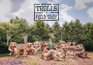 A dozen fanciful troll sculptures in a park 