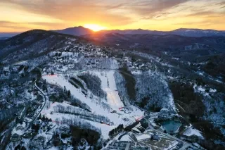 Aerial of Appalachian Ski Mtn. resort with sun setting in background.