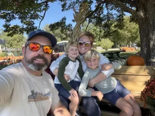 Family taking a selfie at Mike's Farm in Onslow County with pumpkins in background.