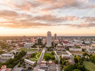 Winston-Salem skyline at golden hour showcasing iconic buildings in summer.