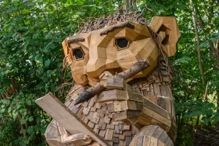 The troll Wilde created by artist Thomas Dambo in a beautiful forest environment