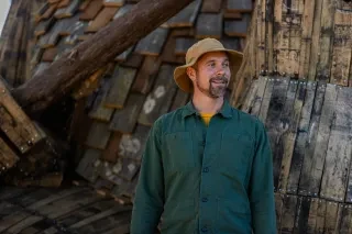 Artist Thomas Dambo stands in front of his impressive troll sculpture in Dix Park in Raleigh, NC