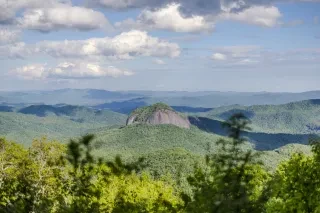 Looking Glass Rock in distance surrounded by mountains and forest near Brevard.