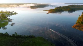 Aerial of boat in calm water during fall on beautiful day.