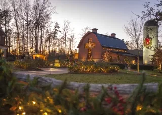 Exterior of Billy Graham Library at dusk with Christmas lights in bushes all around.